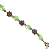 Up-close of beads - chrysolite green glass beads and copper metal beads